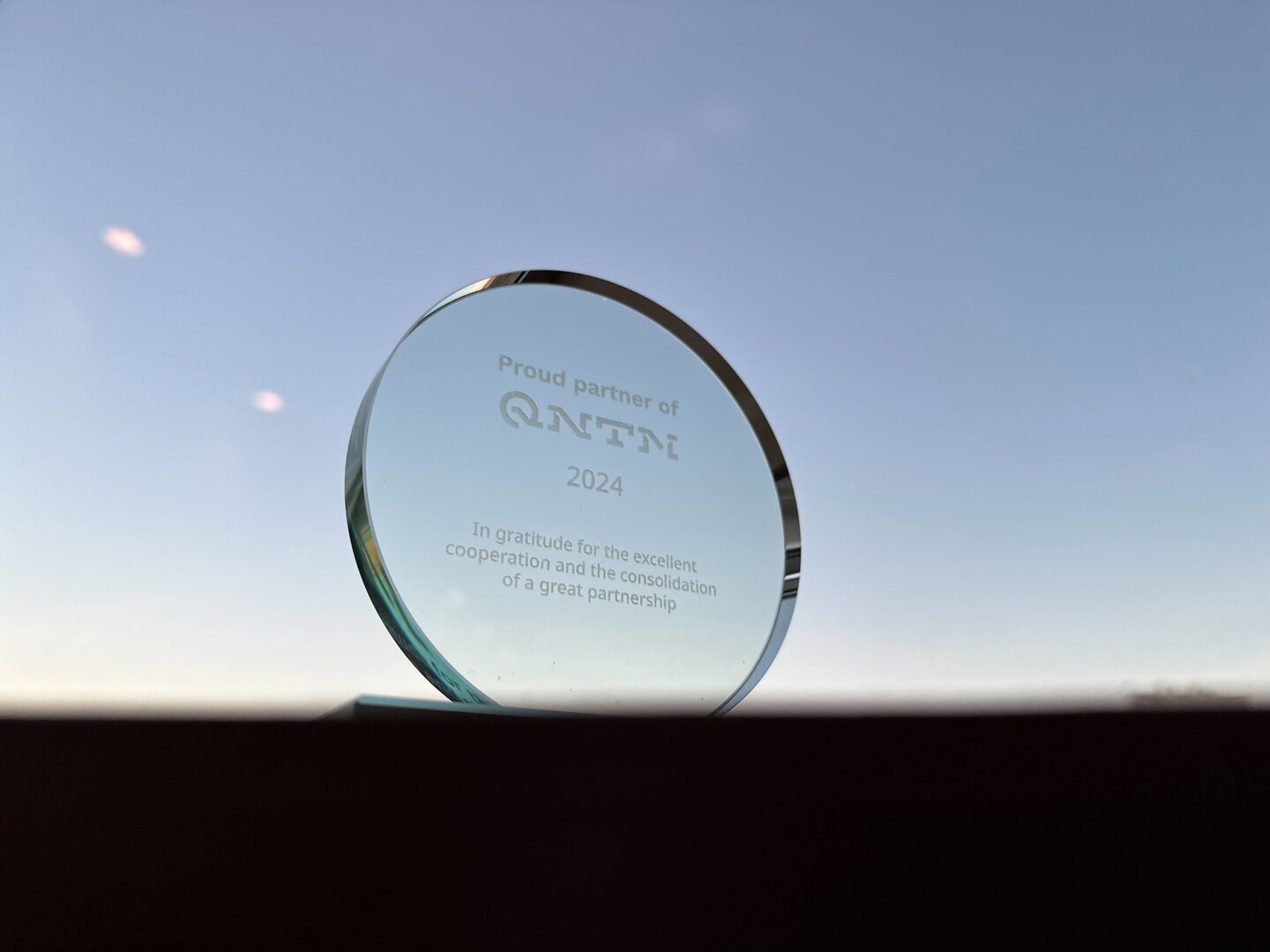 Foto: Pokal "Proud partner of QNTM 2024" für atlantis dx